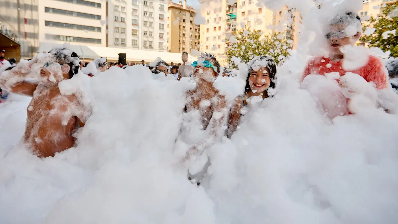 Niños y niñas juegan en la fiesta de la espuma tras el chupinazo de inicio de las Fiestas de Burlada 2025. IÑIGO ALZUGARAY