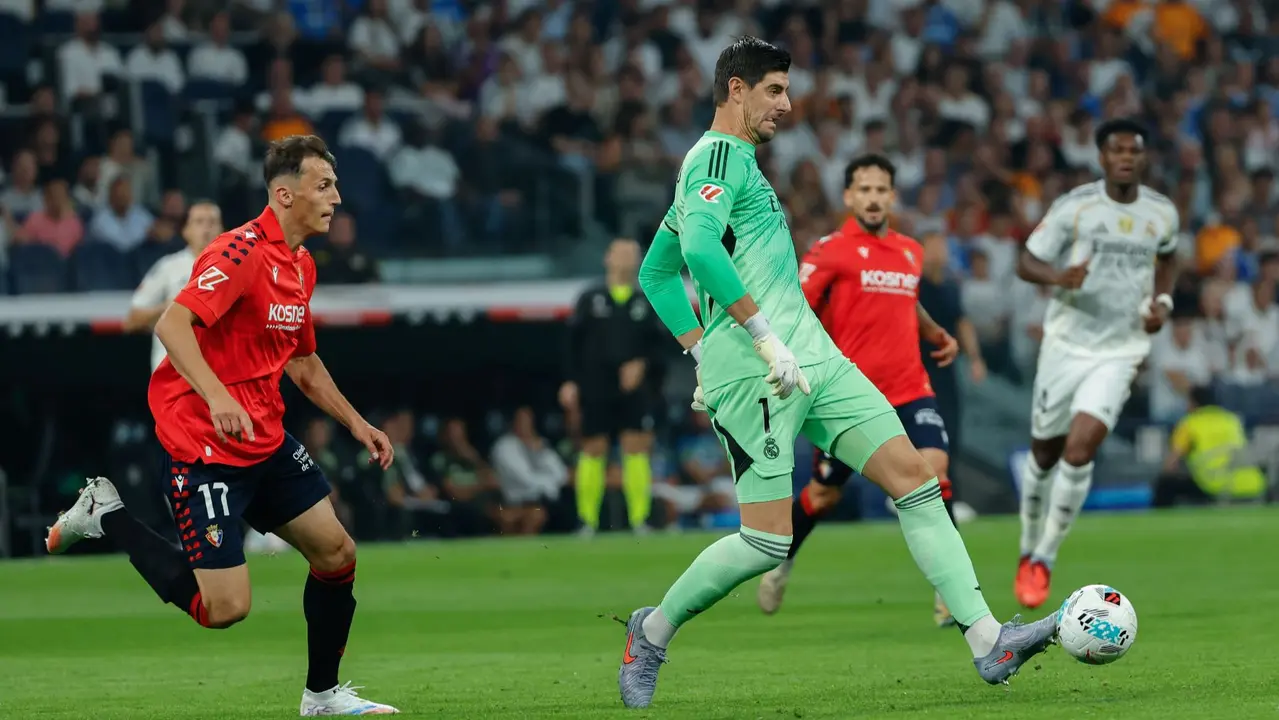 El portero belga del Real Madrid, Thibaut Courtois (c), controla el balón durante el partido de la primera jornada de LaLiga que Real Madrid y Atlético Osasuna disputan hoy martes en el estadio Santiago Bernabéu. EFE/Mariscal