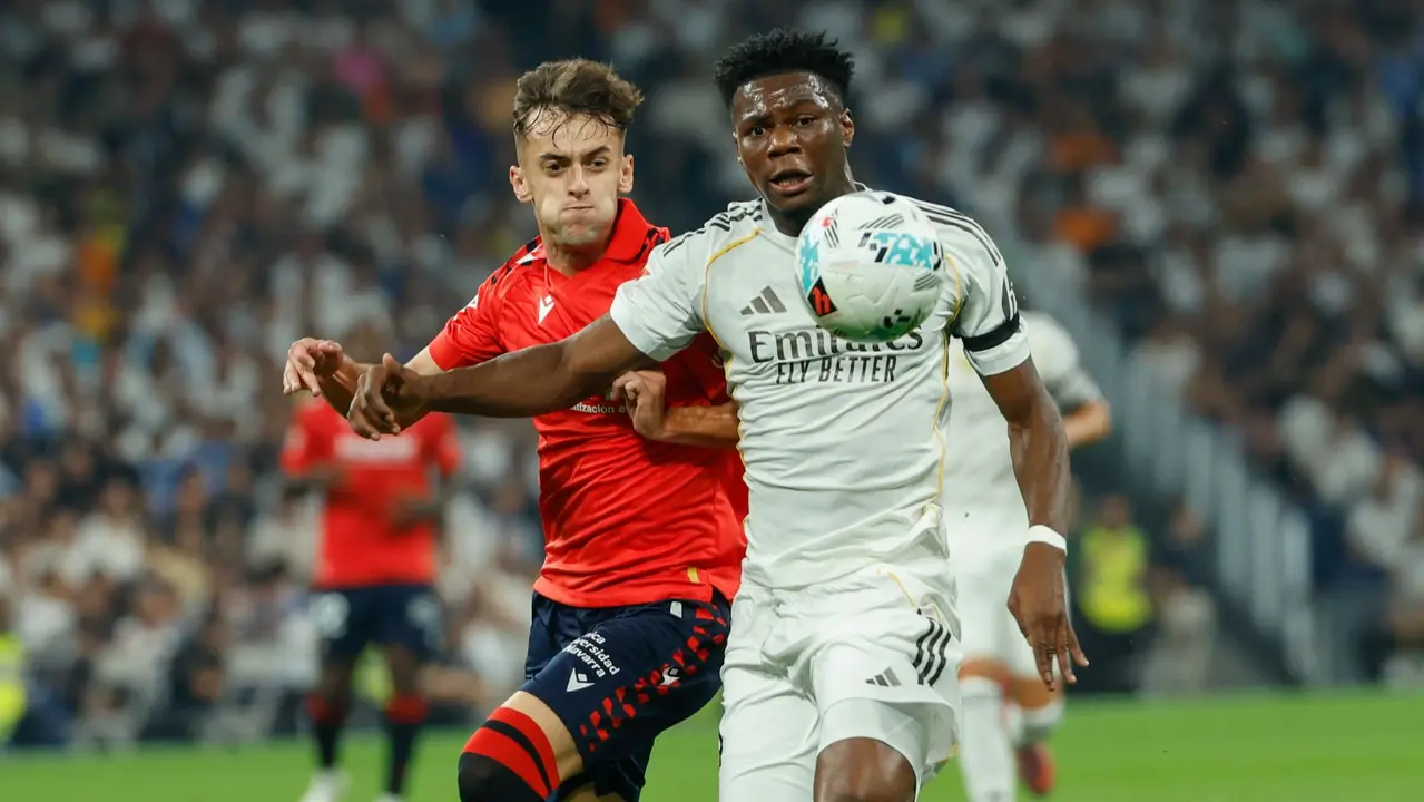 El centrocampista francés del Real Madrid Aurelien Tchouameni (d) lucha con Aimar Oroz, de Osasuna, durante el partido de la primera jornada de LaLiga que Real Madrid y Atlético Osasuna disputan hoy martes en el estadio Santiago Bernabéu. EFE/Mariscal