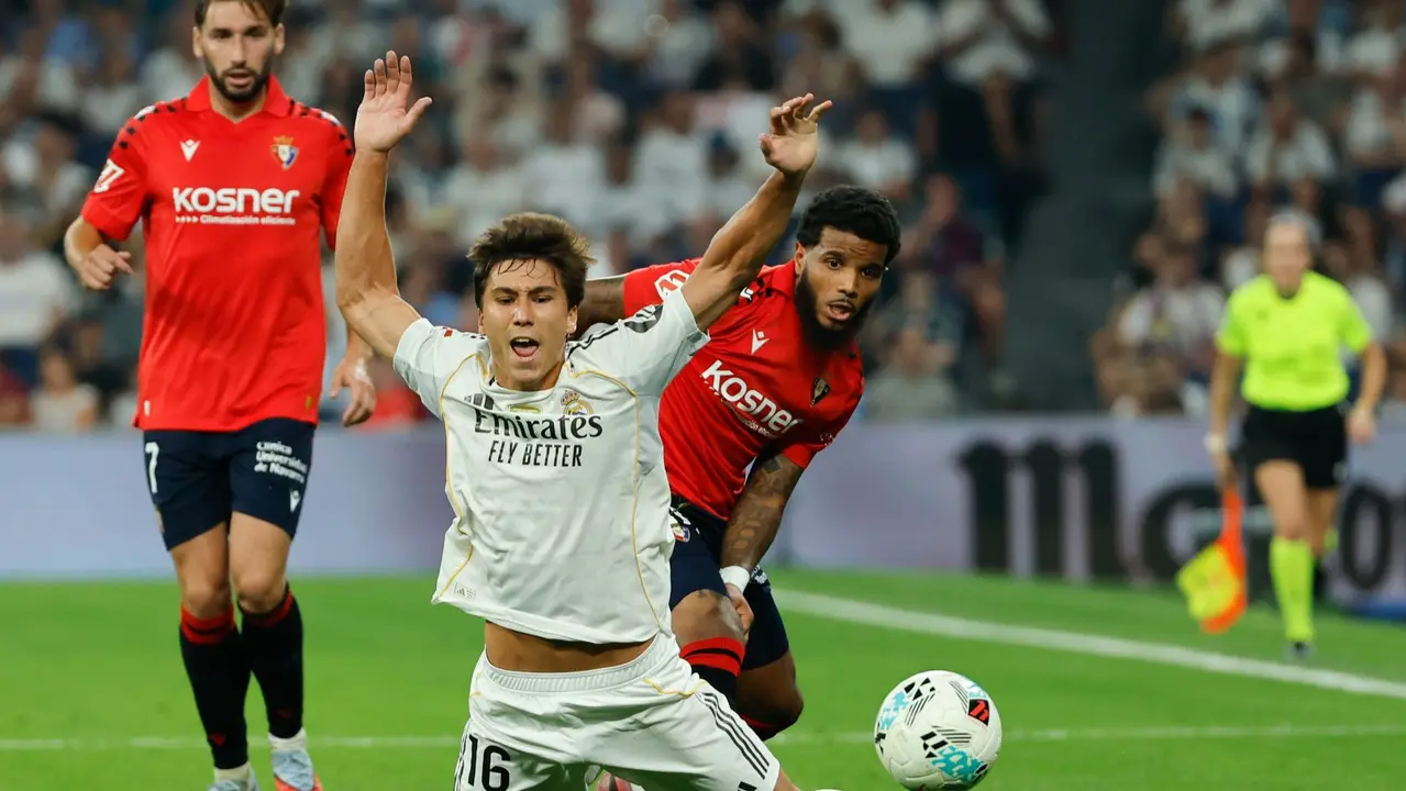 El delantero del Real Madrid Gonzalo García (delante) cae tras la entrada de Valentin Rosier, de Osasuna, durante el partido de la primera jornada de LaLiga que Real Madrid y Atlético Osasuna disputan hoy martes en el estadio Santiago Bernabéu. EFE/Mariscal