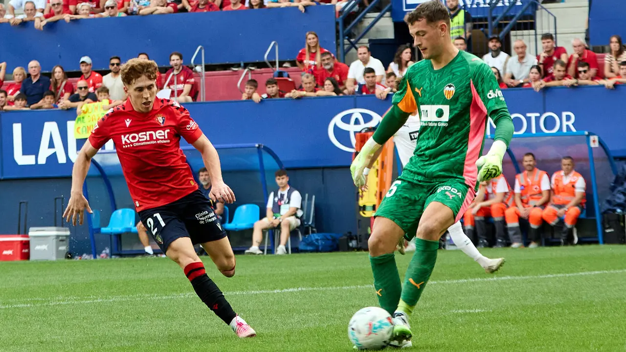 Víctor Muñoz (21. CA Osasuna) y Julen Agirrezabala (25. Valencia CF) durante el partido de La Liga EA Sports entre CA Osasuna y Valencia CF disputado en el estadio de El Sadar en Pamplona. IÑIGO ALZUGARAY