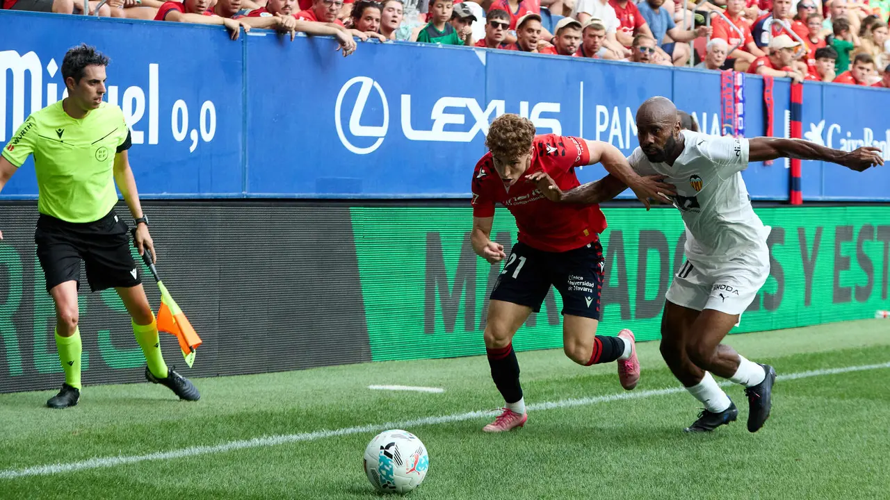 Víctor Muñoz (21. CA Osasuna) y Dimitri Foulquier (20. Valencia CF) durante el partido de La Liga EA Sports entre CA Osasuna y Valencia CF disputado en el estadio de El Sadar en Pamplona. IÑIGO ALZUGARAY
