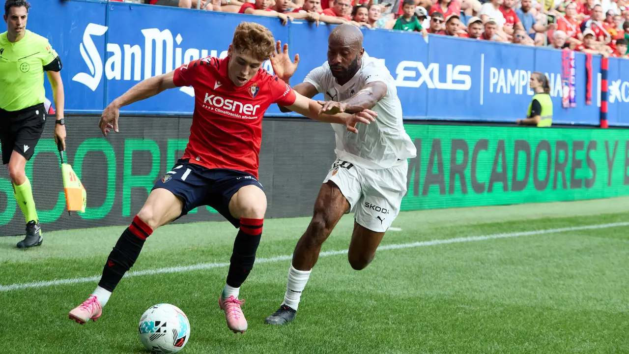 Víctor Muñoz (21. CA Osasuna) y Dimitri Foulquier (20. Valencia CF) durante el partido de La Liga EA Sports entre CA Osasuna y Valencia CF disputado en el estadio de El Sadar en Pamplona. IÑIGO ALZUGARAY