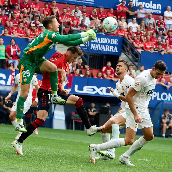 Julen Agirrezabala (25. Valencia CF), Ante Budimir (17. CA Osasuna), José Copete (3. Valencia CF) y César Tárrega (5. Valencia CF) durante el partido de La Liga EA Sports entre CA Osasuna y Valencia CF disputado en el estadio de El Sadar en Pamplona. IÑIGO ALZUGARAY