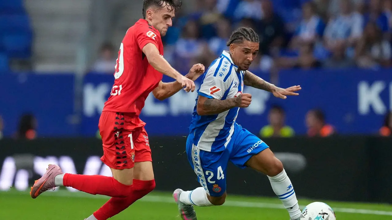 El centrocampista británico del Espanyol Tyrhys Dolan (d) lucha con Aimar Oroz, de Osasuna, durante el partido de la tercera jornada de LaLiga que RCD Espanyol y Atlético Osasuna juegan este domingo en el RCDE Stadium. EFE/Enric Fontcuberta