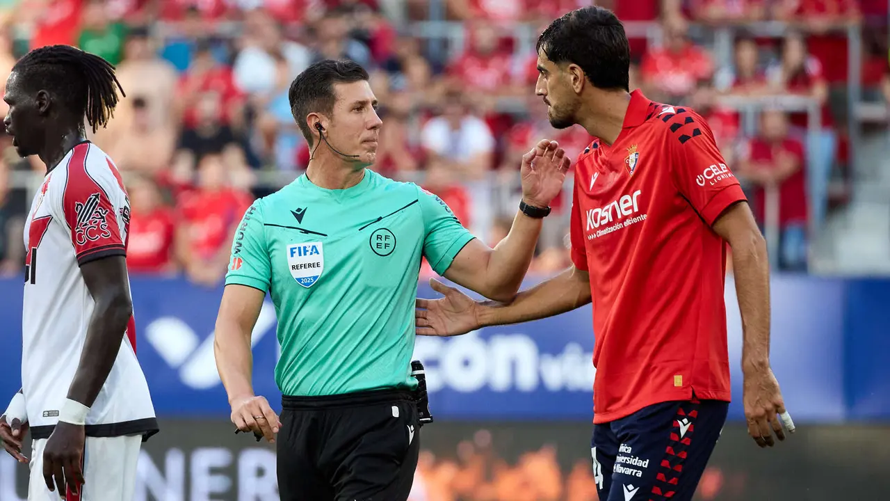 César Soto Grado (árbitro del partido) y Alejandro Catena (24. CA Osasuna) durante el partido de La Liga EA Sports entre CA Osasuna y Rayo Vallecano disputado en el estadio de El Sadar en Pamplona. IÑIGO ALZUGARAY