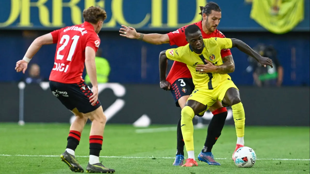 El delantero marfileño del Villarreal Nicolas Pépé (d) pelea un balón ante el defensa del Osasuna Juan Cruz durante el partido de la jornada 5 de LaLiga EA Sports que disputan el Villarreal y el Osasuna este sábado en el estadio de La Cerámica. EFE/ Andreu Esteban