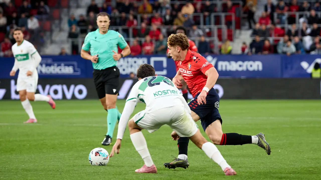 Victor Chust (23. Elche CF) y Víctor Muñoz (21. CA Osasuna) durante el partido de La Liga EA Sports entre CA Osasuna y Elche CF disputado en el estadio de El Sadar en Pamplona. IÑIGO ALZUGARAY