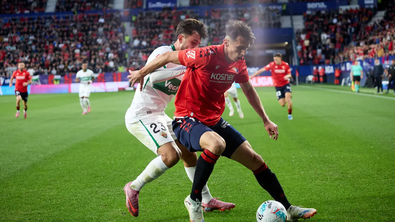 Victor Chust (23. Elche CF) y Ante Budimir (17. CA Osasuna) durante el partido de La Liga EA Sports entre CA Osasuna y Elche CF disputado en el estadio de El Sadar en Pamplona. IÑIGO ALZUGARAY