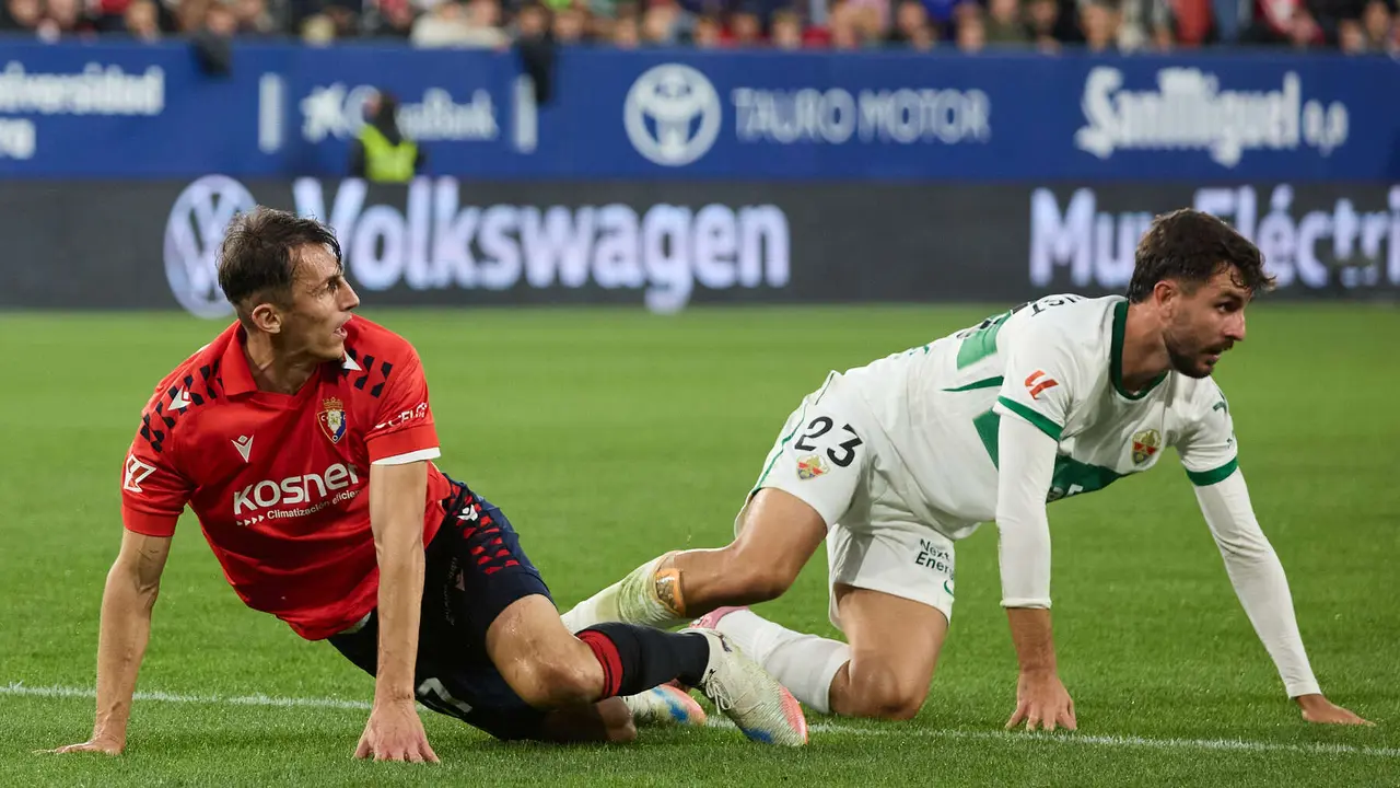Ante Budimir (17. CA Osasuna) y Victor Chust (23. Elche CF) durante el partido de La Liga EA Sports entre CA Osasuna y Elche CF disputado en el estadio de El Sadar en Pamplona. IÑIGO ALZUGARAY