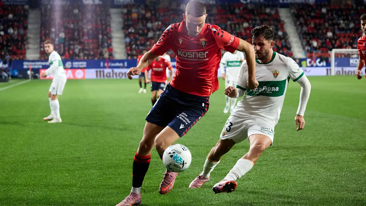 Raúl García (9. CA Osasuna) y Victor Chust (23. Elche CF) durante el partido de La Liga EA Sports entre CA Osasuna y Elche CF disputado en el estadio de El Sadar en Pamplona. IÑIGO ALZUGARAY
