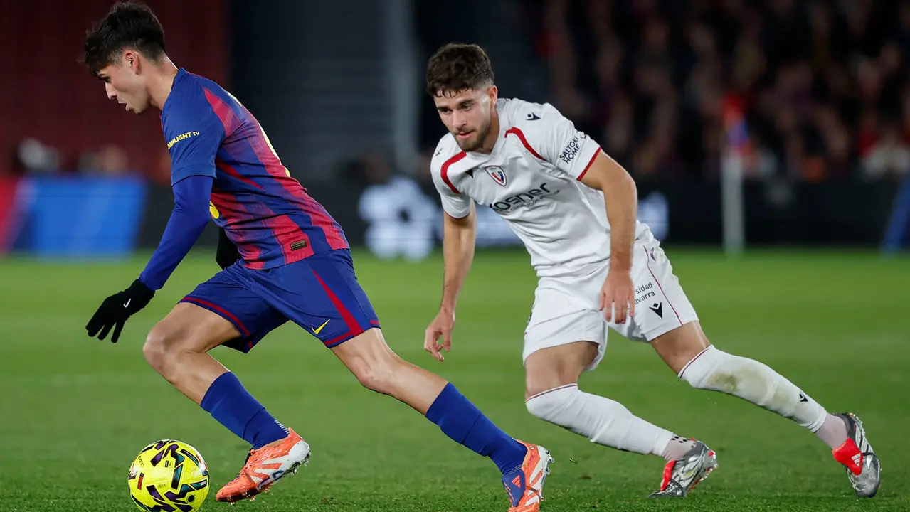 El centrocampista del FC Barcelona Pedri (i) se escapa con el balón durante el partido de la jornada 16 de LaLiga que FC Barcelona y Atlético Osasuna disputan este sábado en el Camp Nou. EFE/Andreu Dalmau