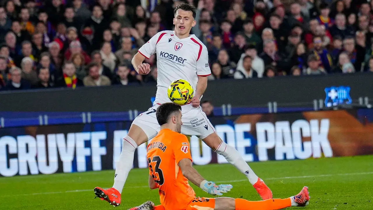 El delantero croata de Osasuna Ante Budimir (detrás) intenta superar a Joan García, guardameta del FC Barcelona, durante el partido de la jornada 16 de LaLiga que FC Barcelona y Atlético Osasuna disputan este sábado en el Camp Nou. EFE/Alejandro García