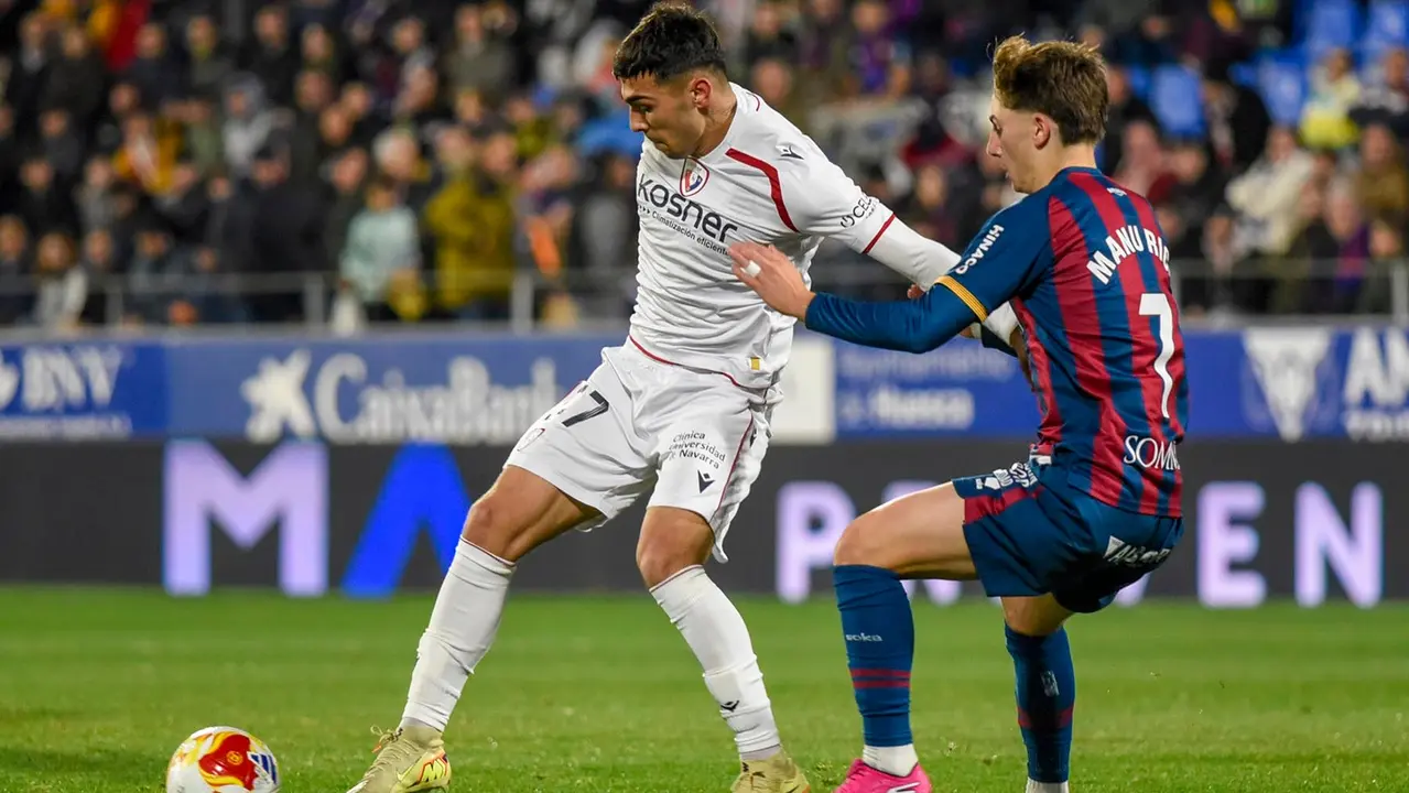 El delantero de Osasuna Robert Arroyo (i) pelea un bal&oacute;n con el centrocampista del Huesca Manu Rico, durante el partido de dieciseisavos de final de la Copa del Rey entre el Huesca y el Osasuna, este mi&eacute;rcoles en el estadio de El Alcoraz, en Huesca. EFE/ Javier Blasco