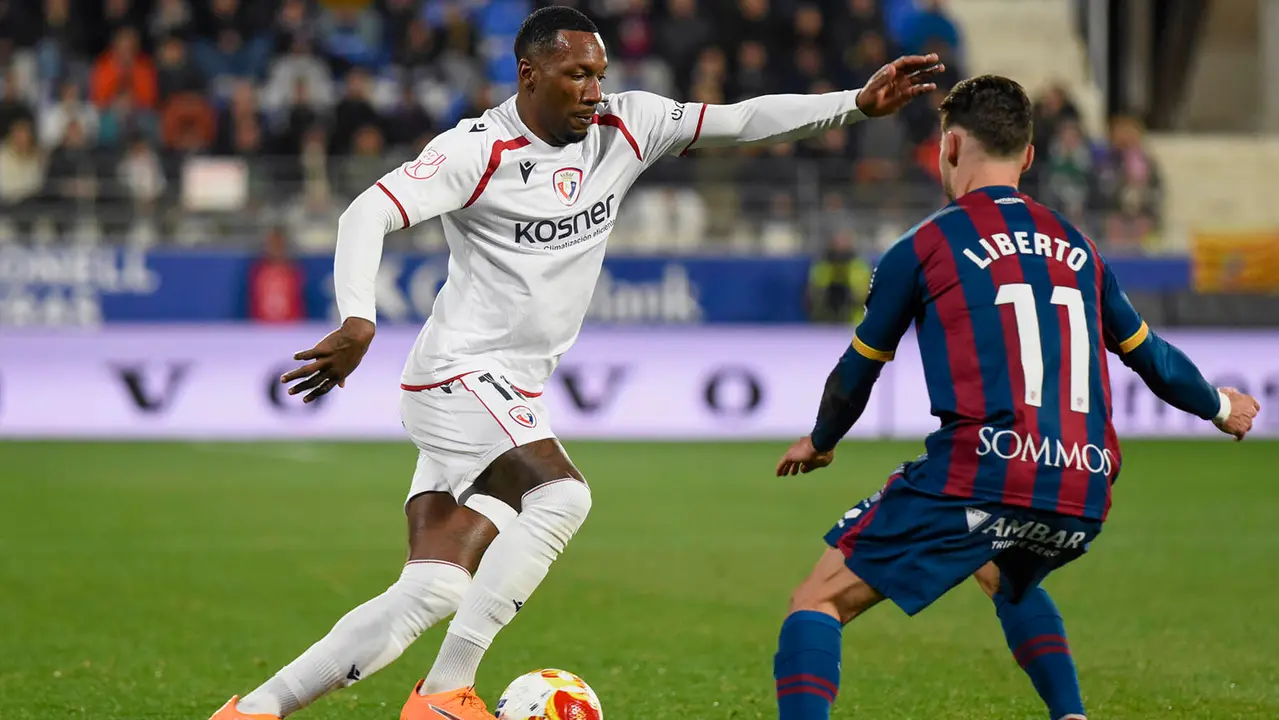 HUESCA , 17/12/2025.- El centrocampista surinam&eacute;s de Osasuna Sheraldo Becker (i) pelea un bal&oacute;n con el delantero del Huesca Liberto Beltr&aacute;n, durante el partido de dieciseisavos de final de la Copa del Rey entre el Huesca y el Osasuna, este mi&eacute;rcoles en el estadio de El Alcoraz, en Huesca. EFE/ Javier Blasco