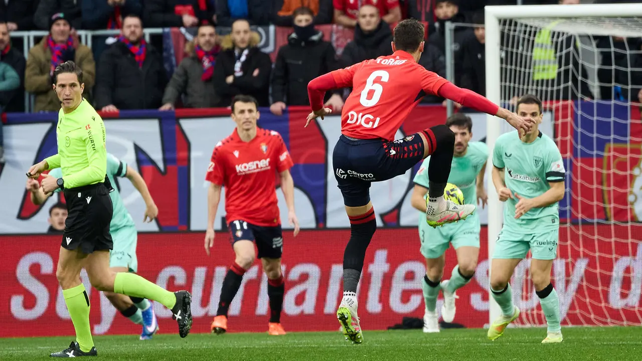 Jos&eacute; Luis Munuera Montero (&aacute;rbitro del partido) y Lucas Torr&oacute; (6. CA Osasuna) durante el partido de La Liga EA Sports entre CA Osasuna y Athletic Club disputado en el estadio de El Sadar en Pamplona. I&Ntilde;IGO ALZUGARAY