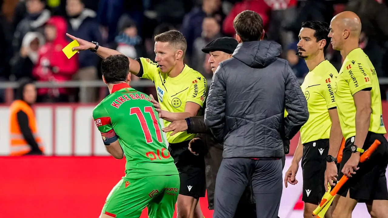 El colegiado Hern&aacute;ndez Hern&aacute;ndez y el centrocampista de Osasuna, Kike Barja, tras una jugada pol&eacute;mica durante el encuentro Girona - Osasuna. EFE/David Borrat.