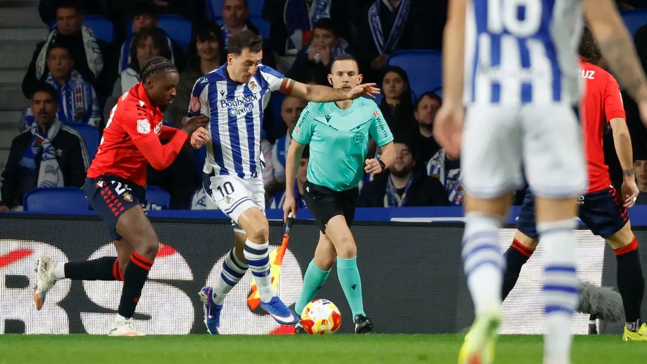 El delantero de la Real Sociedad, Mikel Oyarzabal (2i), intenta llevarse el bal&oacute;n ante el defensa camerun&eacute;s de Osasuna, Enzo Boyomo, durante el encuentro correspondiente a los octavos de final de la Copa del Rey que disputan hoy martes en el estadio de Anoeta, en San Sebasti&aacute;n. EFE / Javier Etxezarreta.