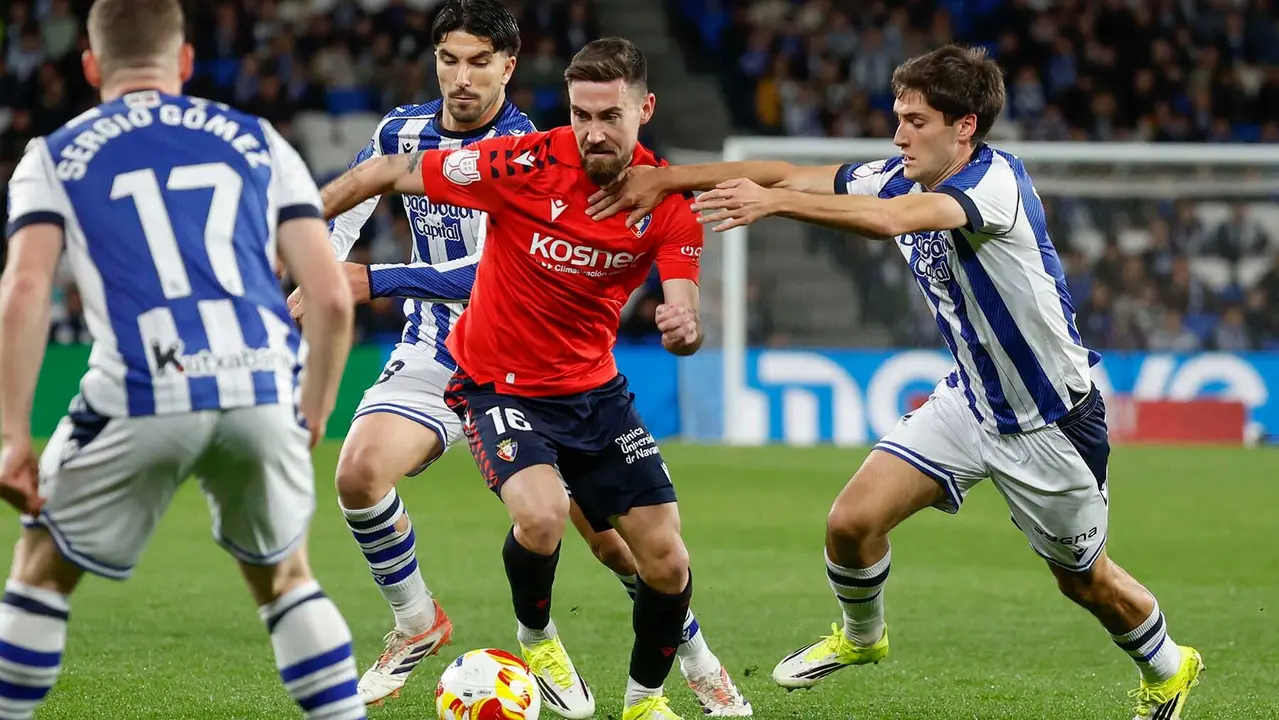 El delantero de Osasuna Moi G&oacute;mez (2d) intenta escaparse de los jugadores de la Real Sociedad, durante el encuentro correspondiente a los octavos de final de la Copa del Rey que disputan Real Sociedad y Atl&eacute;tico Osasuna hoy martes en el estadio de Anoeta, en San Sebasti&aacute;n. EFE/ Javier Etxezarreta.