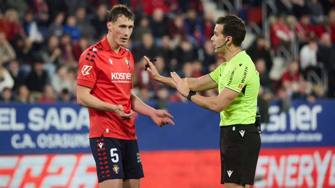 Jorge Herrando (5. CA Osasuna) y Alejandro Quintero Gonz&aacute;lez (&aacute;rbitro del partido) durante el partido de La Liga EA Sports entre CA Osasuna y Real Madrid CF disputado en el estadio de El Sadar en Pamplona. I&Ntilde;IGO ALZUGARAY