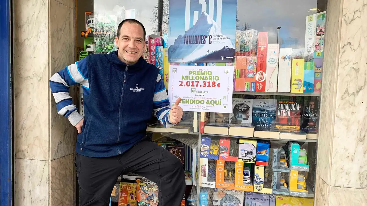 Aitor Idiazabal Ayesa se&ntilde;ala el cartel colocado en su librer&iacute;a con la cantidad entregada en la Bonoloto. Navarra.com