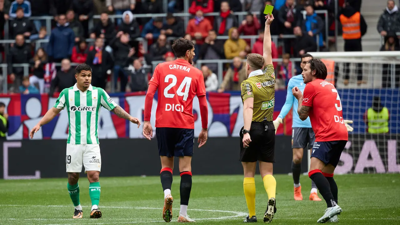 Miguel Sesma Espinosa (&aacute;rbitro del partido) muestra una tarjeta aAprilla a Cucho Hern&aacute;ndez (19. Real Betis) durante el partido de La Liga EA Sports entre CA Osasuna y Real Betis disputado en el estadio de El Sadar en Pamplona. I&Ntilde;IGO ALZUGARAY