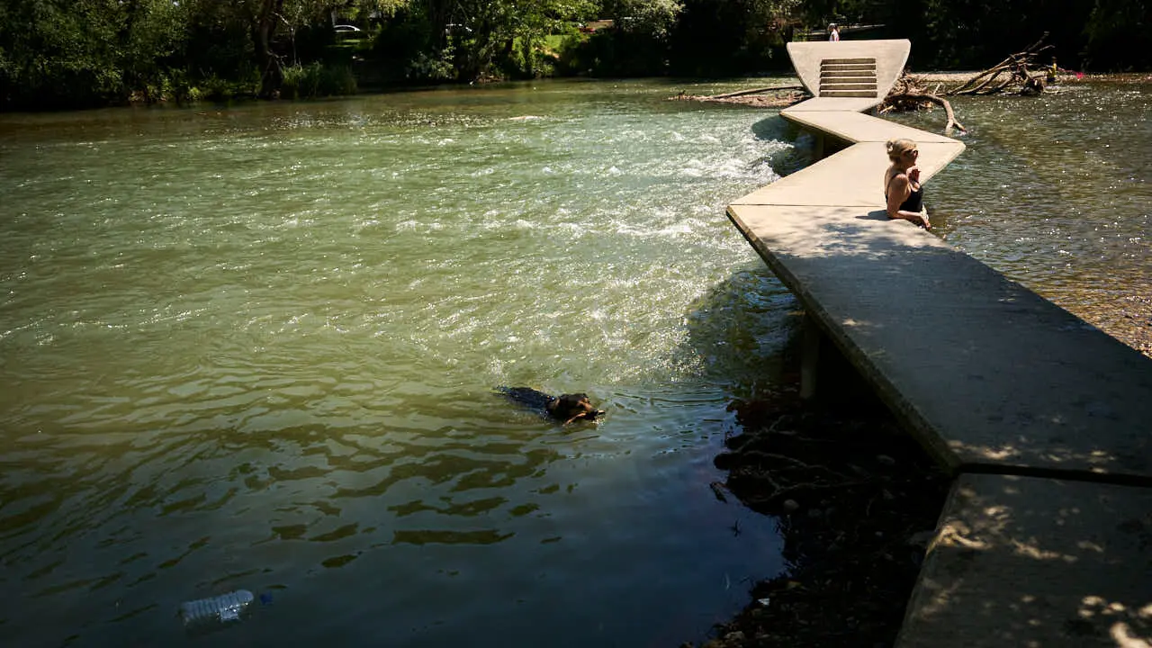 Decenas de personas aprovechan las altas temperaturas para refrescarse y disfrutar del r&iacute;o Arga a su paso por Pamplona. PABLO LASAOSA