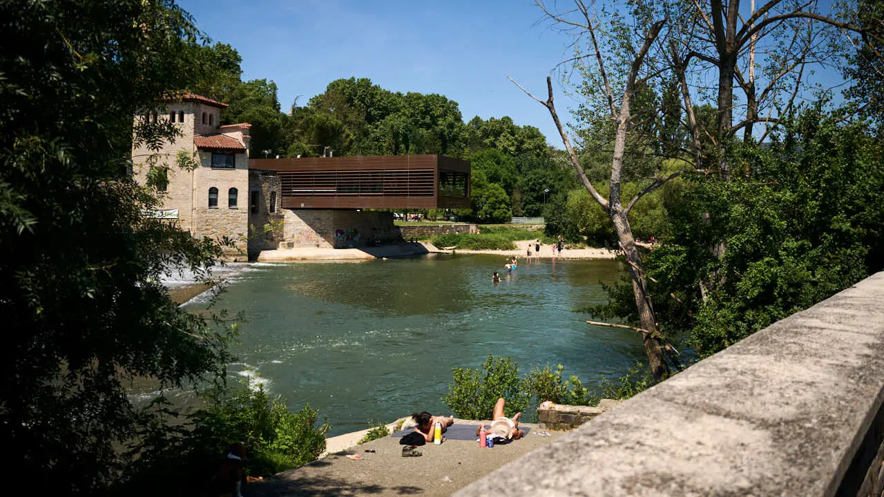 Decenas de personas aprovechan las altas temperaturas para refrescarse y disfrutar del r&iacute;o Arga a su paso por Pamplona. PABLO LASAOSA