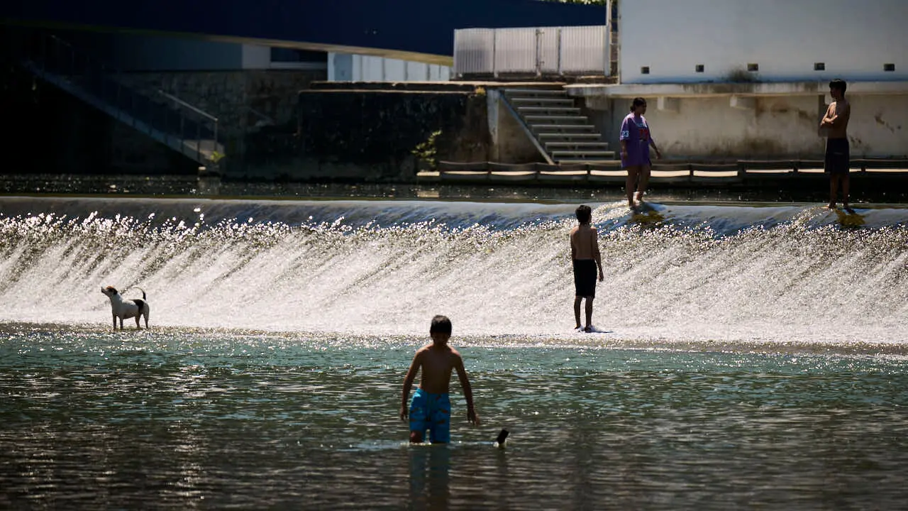 Decenas de personas aprovechan las altas temperaturas para refrescarse y disfrutar del r&iacute;o Arga a su paso por Pamplona. PABLO LASAOSA