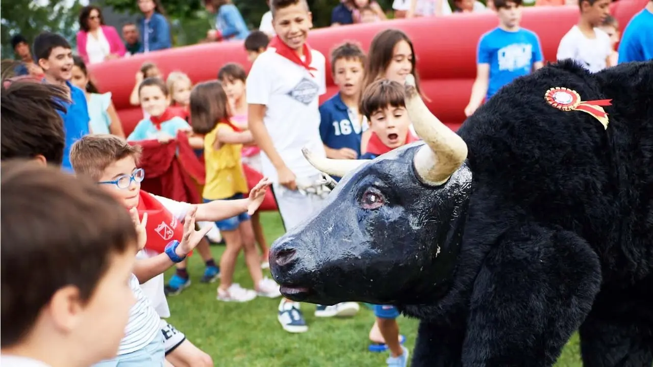 Los chavales disfrutan con el encierro del toro de cart&oacute;n . Foto Club de Tenis Pamplona.
