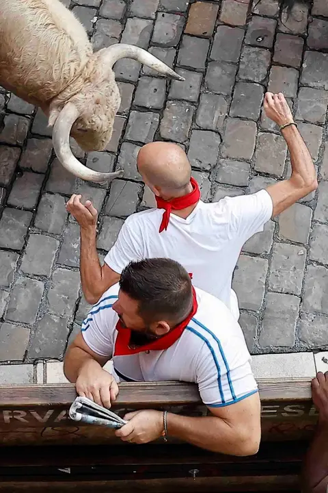 PAMPLONA, 07/07/2026.- Un mozo ante uno de los toros de la ganader&iacute;a Fuente Ymbro a su paso por la Plaza Consistorial en el primer encierro de los Sanfermines 2026, este martes en Pamplona. EFE/Villar L&oacute;pez