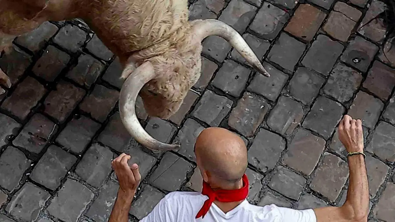 PAMPLONA, 07/07/2026.- Un mozo ante uno de los toros de la ganader&iacute;a Fuente Ymbro a su paso por la Plaza Consistorial en el primer encierro de los Sanfermines 2026, este martes en Pamplona. EFE/Villar L&oacute;pez