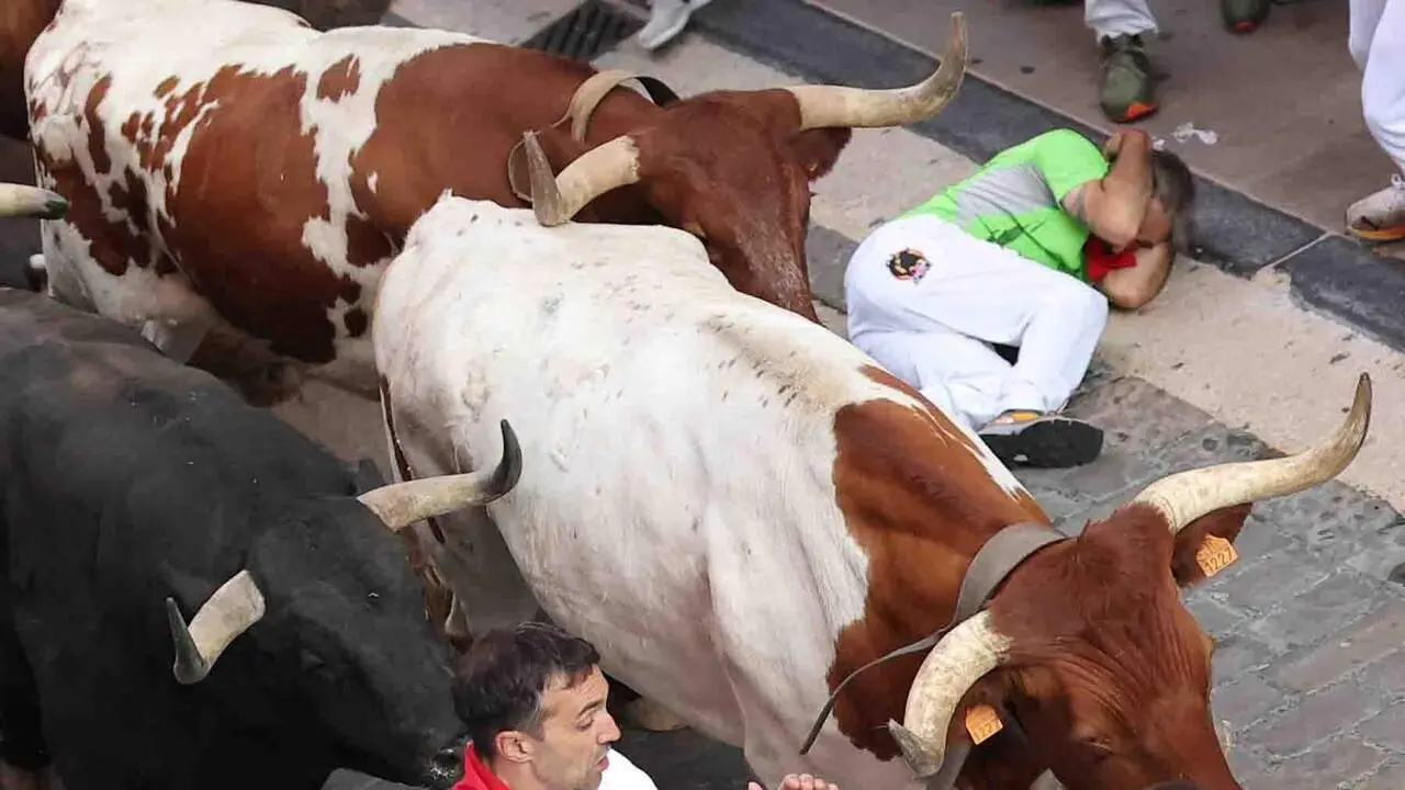 PAMPLONA, 09/07/2026.- Los mozos son perseguidos por los toros de Victoriano del R&iacute;o desde el final de la cuesta de Santo Domingo a la curva de Mercaderes, durante el tercer encierro de los Sanfermines, este jueves en Pamplona. EFE/ J.P. Urdiroz