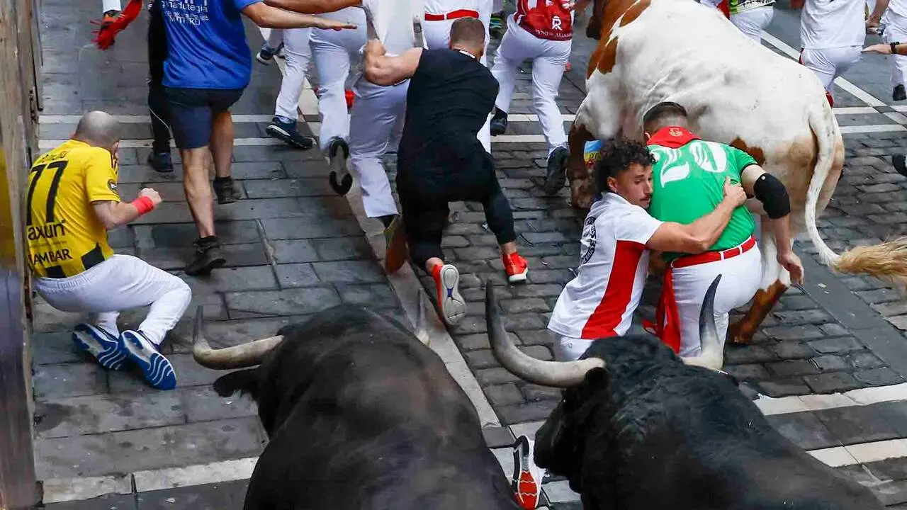 PAMPLONA, 09/07/2026.- Varios mozos caen al paso de los toros de Victoriano del R&iacute;o en el tramo de Mercaderes durante el tercer encierro de los Sanfermines, este jueves en Pamplona. EFE/ Jes&uacute;s Diges