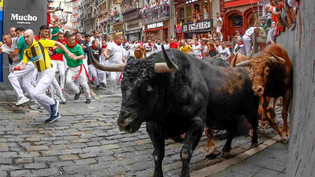 PAMPLONA, 10/07/2026.- Los mozos son perseguidos por los toros de la ganader&iacute;a de &Aacute;lvaro N&uacute;&ntilde;ez en el tramo de Mercaderes durante el cuarto encierro de los Sanfermines 2026 este viernes en Pamplona. EFE/ Jes&uacute;s Diges