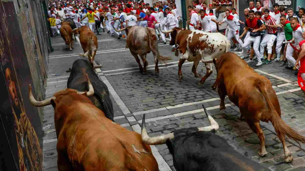 PAMPLONA, 10/07/2026.- Los mozos son perseguidos por los toros de la ganader&iacute;a de &Aacute;lvaro N&uacute;&ntilde;ez en el tramo de Mercaderes durante el cuarto encierro de los Sanfermines 2026 este viernes en Pamplona. EFE/ Jes&uacute;s Diges