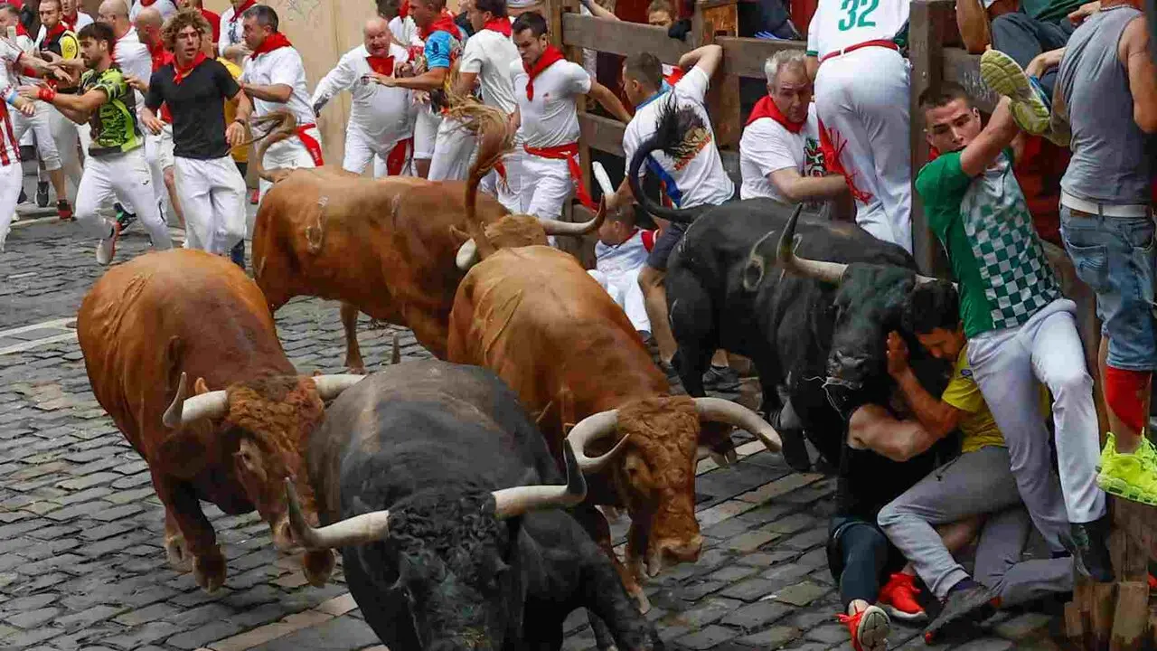PAMPLONA, 10/07/2026.- Varios mozos son embestidos por uno de los toro de la ganader&iacute;a de &Aacute;lvaro N&uacute;&ntilde;ez en el tramo de Mercaderes durante el cuarto encierro de los Sanfermines 2026 este viernes en Pamplona. EFE/ Jes&uacute;s Diges