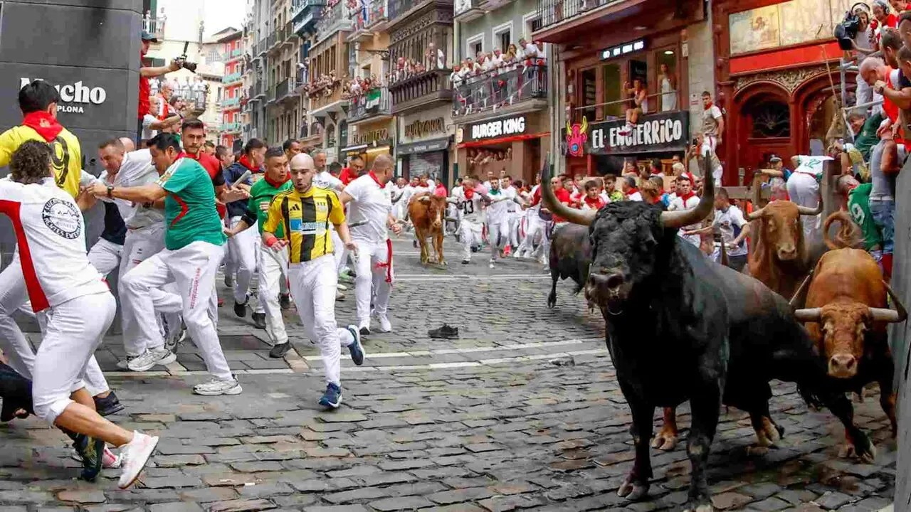 PAMPLONA, 10/07/2026.- Los mozos son perseguidos por los toros de la ganader&iacute;a de &Aacute;lvaro N&uacute;&ntilde;ez en el tramo de Mercaderes durante el cuarto encierro de los Sanfermines 2026 este viernes en Pamplona. EFE/ Jes&uacute;s Diges