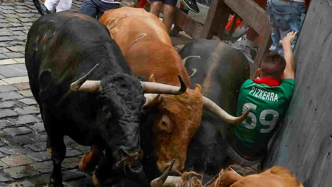 PAMPLONA, 10/07/2026.- Un mozo, acorralado por los toros &Aacute;lvaro N&uacute;&ntilde;ez durante el cuarto encierro de los Sanfermines 2026 este viernes en Pamplona. EFE/Jesus Diges