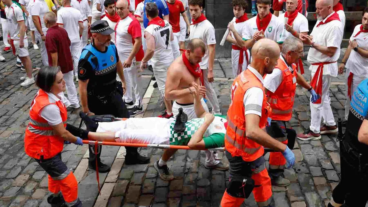 PAMPLONA, 10/07/2026.- Sanitarios de la Cruz Roja evac&uacute;an a uno de los mozos heridos en el tramo de Mercaderes durante el cuarto encierro de los Sanfermines 2026 este viernes en Pamplona. EFE/ Jes&uacute;s Diges