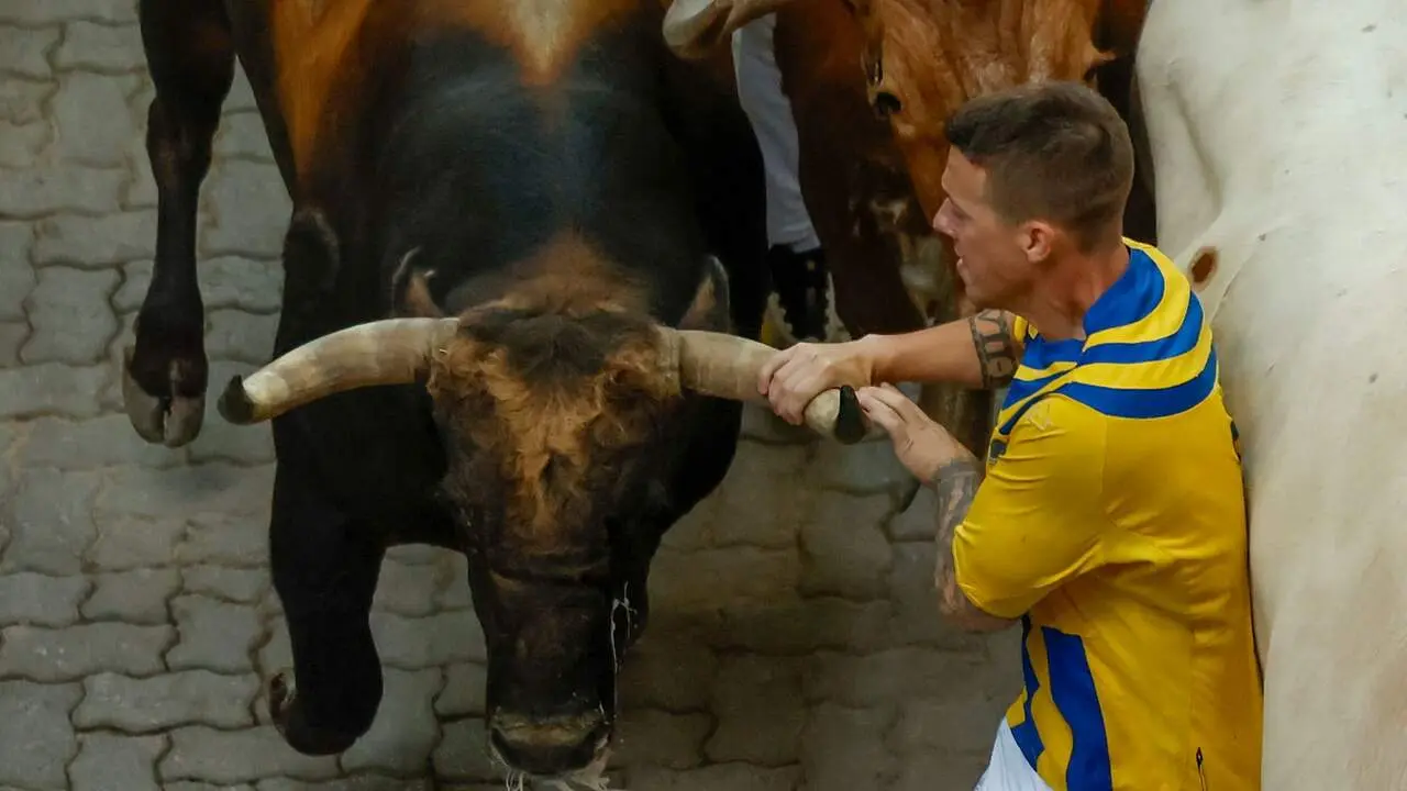 Mozo arrollado en la bajada al callej&oacute;n en el sexto encierro de San Ferm&iacute;n con toros de La Palmosilla. EFE / JES&Uacute;S DIGES