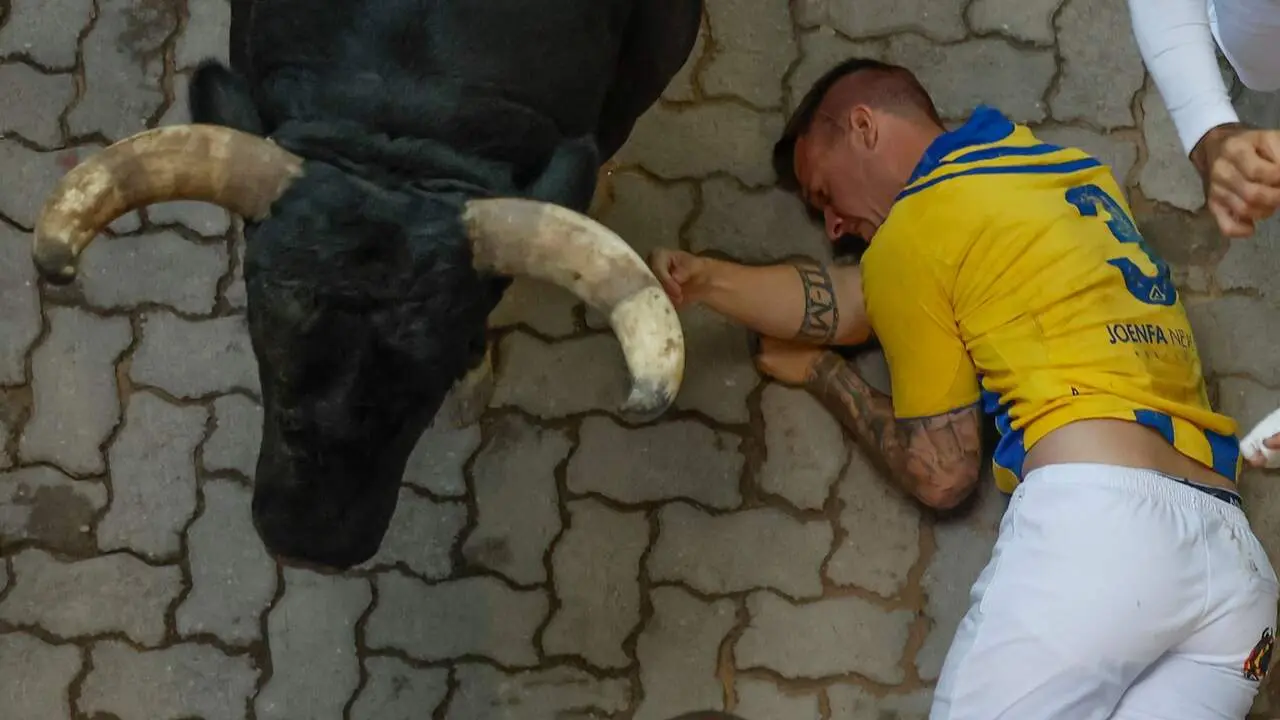 Mozo arrollado en la bajada al callej&oacute;n en el sexto encierro de San Ferm&iacute;n con toros de La Palmosilla. EFE / JES&Uacute;S DIGES