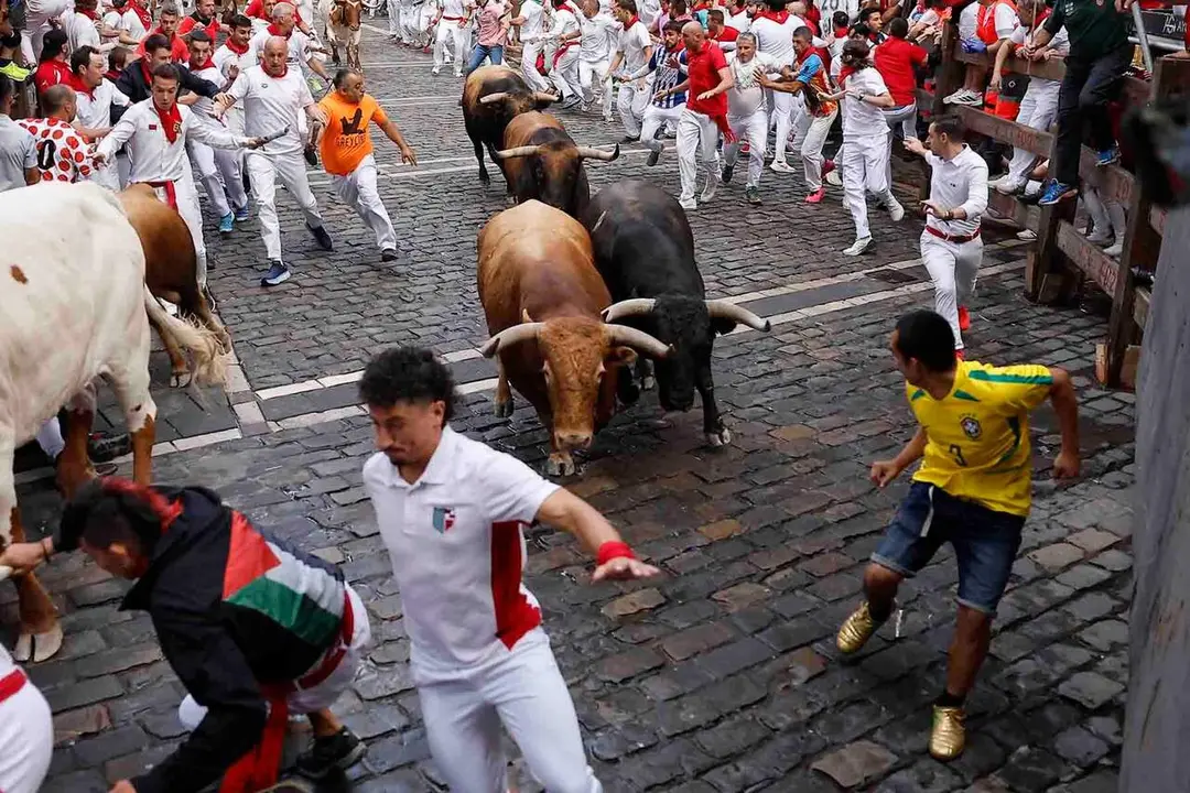 'Mozos' or runners are chased by the bulls of La Palmosilla ranch at Mercaderes street during the sixth running of the bulls of Sanfermines festival in Pamplona, northern Spain, 12 July 2026. Sanfermines festival runs until 14 July at midnight. EFE/Villar Lopez