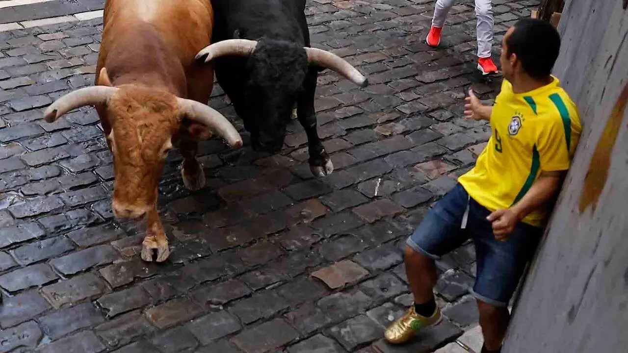 PAMPLONA, 12/07/2026.- Los toros de la ganader&iacute;a gaditana de La Palmosilla entran en la curva de Mercaderes durante el sexto encierro de los Sanfermines 2026, este domingo en Pamplona. EFE/Villar L&oacute;pez