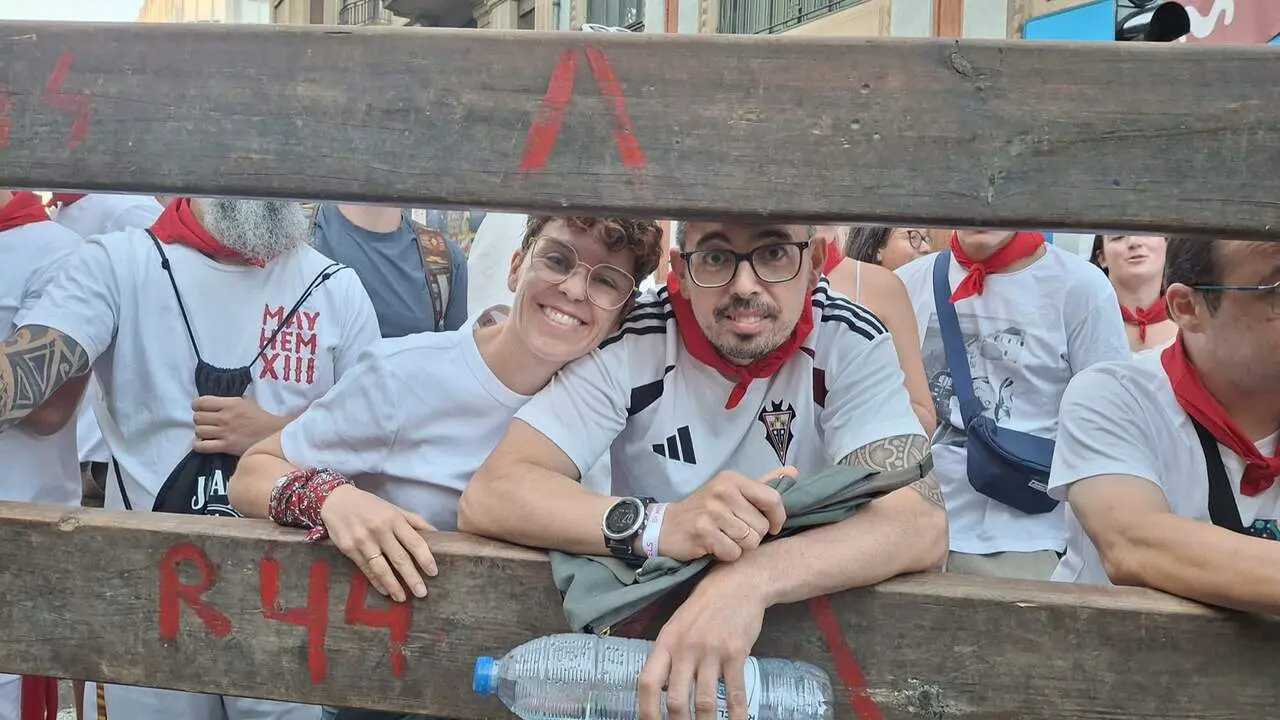 Ana y Javi, un matrimonio venido desde Murcia, esperan en el vallado para ver el &uacute;ltimo encierro de 2026. JOS&Eacute; MIGUEL MONTES