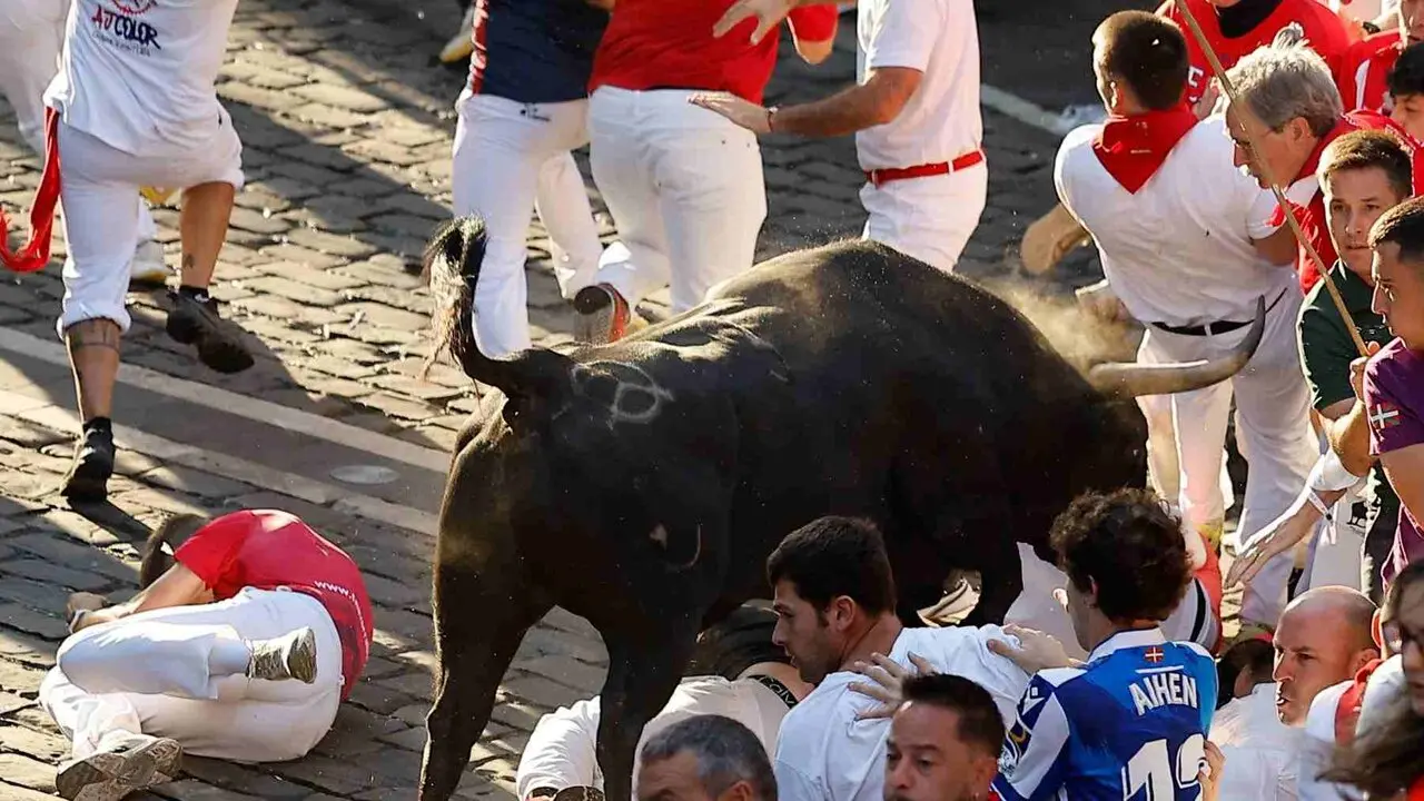 Un toro de la ganader&iacute;a extreme&ntilde;a de Jandilla embiste a varios mozos a su entrada en la calle Mercaderes durante el &uacute;ltimo encierro de los Sanfermines 2026. EFE / VILLAR L&Oacute;PEZ