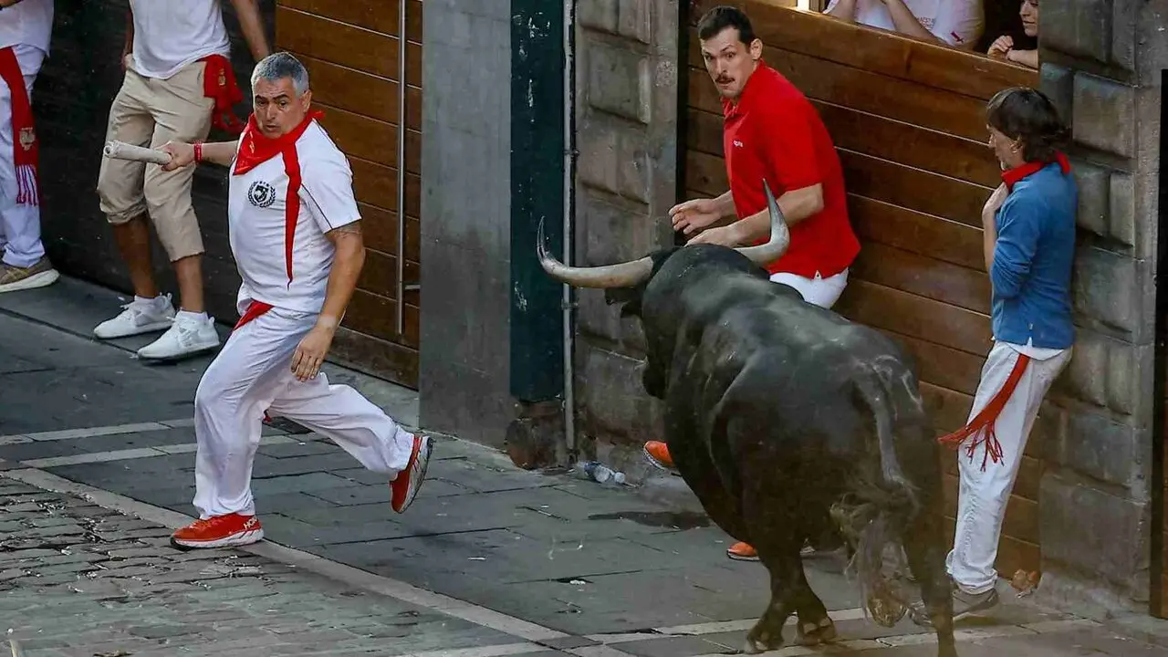 Un toro de la ganader&iacute;a extreme&ntilde;a de Jandilla embiste a varios mozos a su entrada en la calle Mercaderes durante el &uacute;ltimo encierro de los Sanfermines 2026. EFE / VILLAR L&Oacute;PEZ