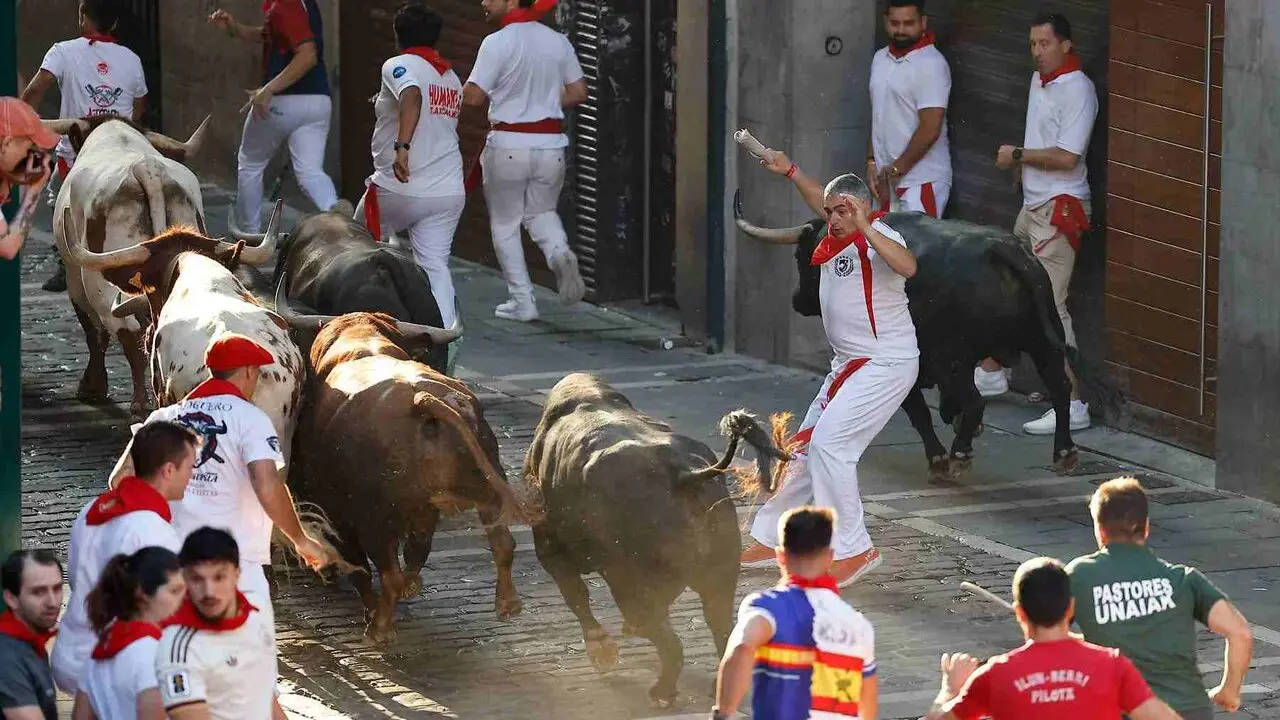 Un toro de la ganader&iacute;a extreme&ntilde;a de Jandilla embiste a varios mozos a su entrada en la calle Mercaderes durante el &uacute;ltimo encierro de los Sanfermines 2026. EFE / VILLAR L&Oacute;PEZ