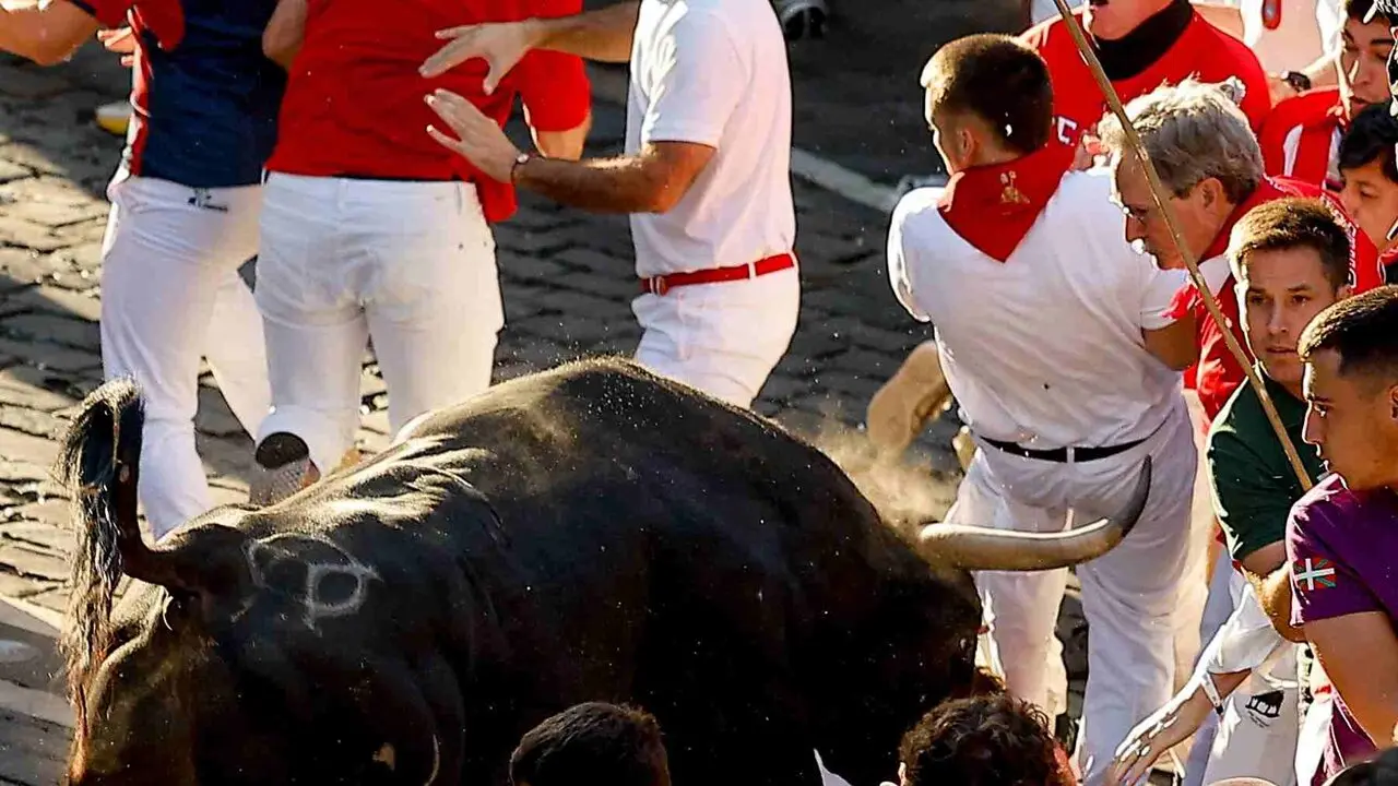 Un toro de la ganader&iacute;a extreme&ntilde;a de Jandilla embiste a varios mozos a su entrada en la calle Mercaderes durante el &uacute;ltimo encierro de los Sanfermines 2026. EFE / VILLAR L&Oacute;PEZ