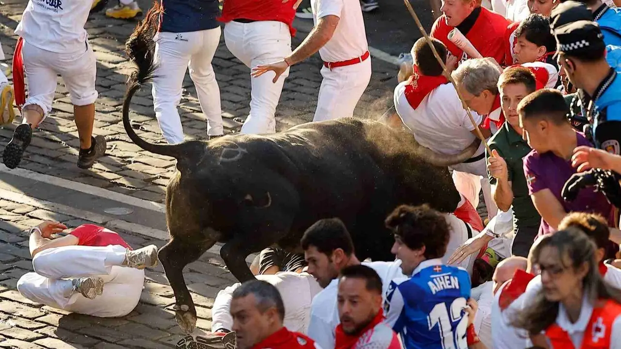 Un toro de la ganader&iacute;a extreme&ntilde;a de Jandilla embiste a varios mozos a su entrada en la calle Mercaderes durante el &uacute;ltimo encierro de los Sanfermines 2026. EFE / VILLAR L&Oacute;PEZ